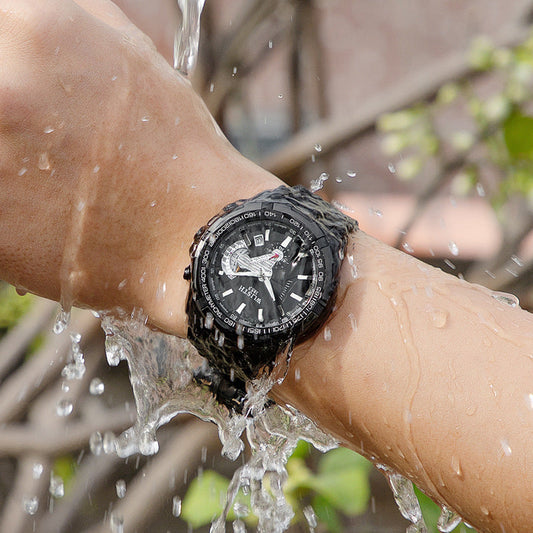 Black watch on a wrist with water droplets, outdoor background