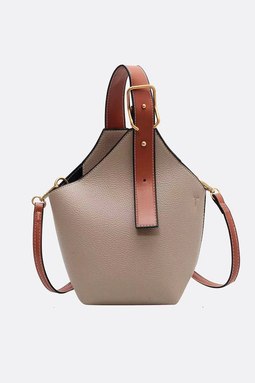 Beige handbag with brown leather straps on a white background