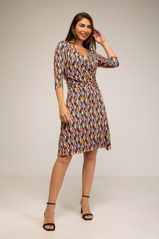 Woman wearing a colorful patterned dress on a plain background
