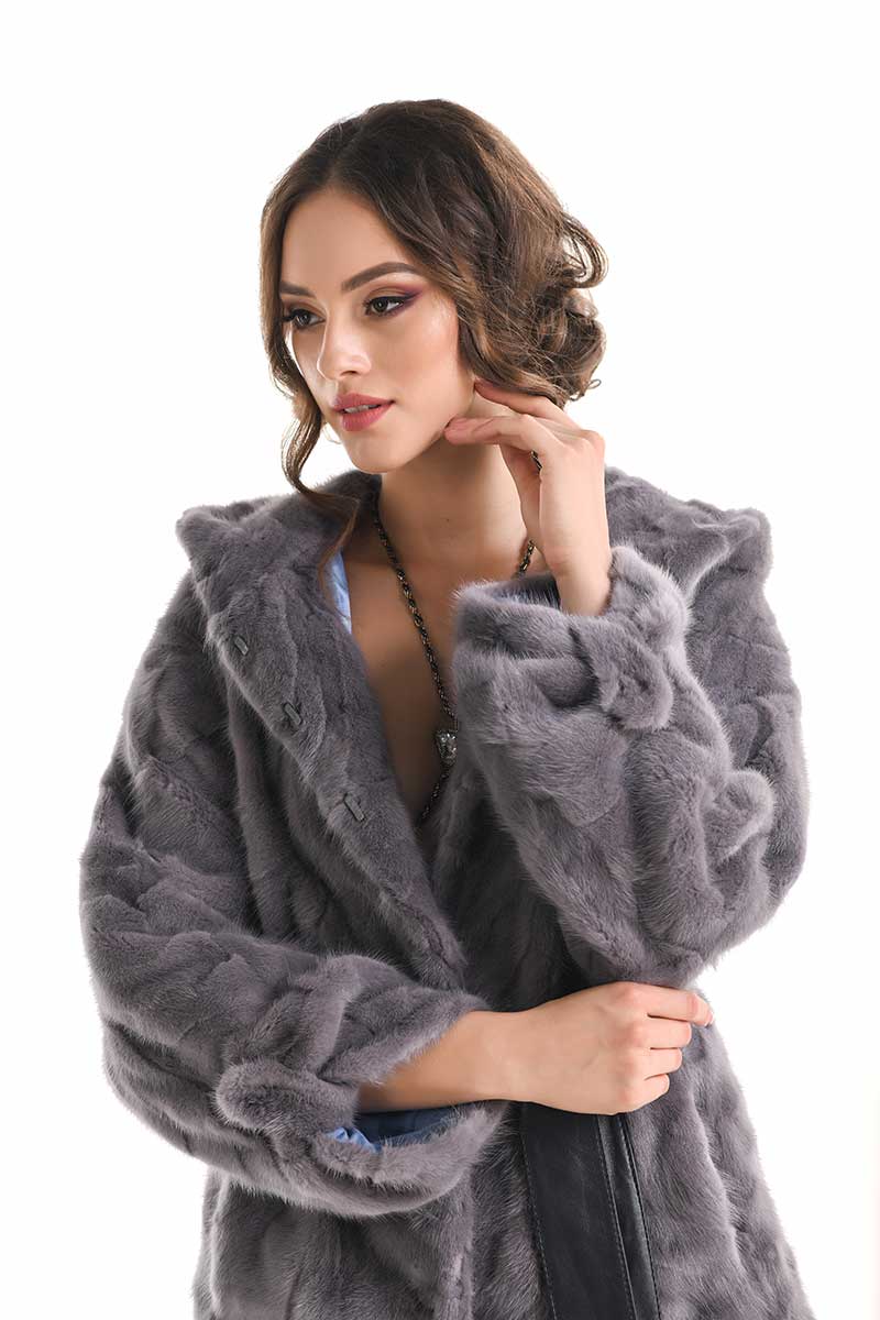 Woman wearing a gray fur coat on a white background