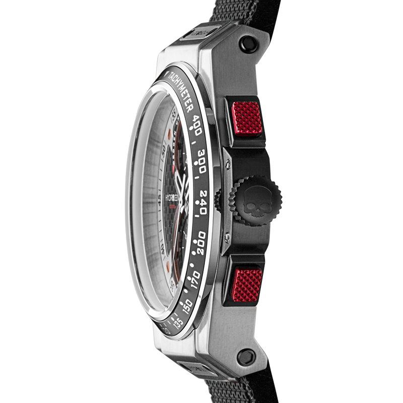 Close-up of a watch with a metallic case and red accents on a white background