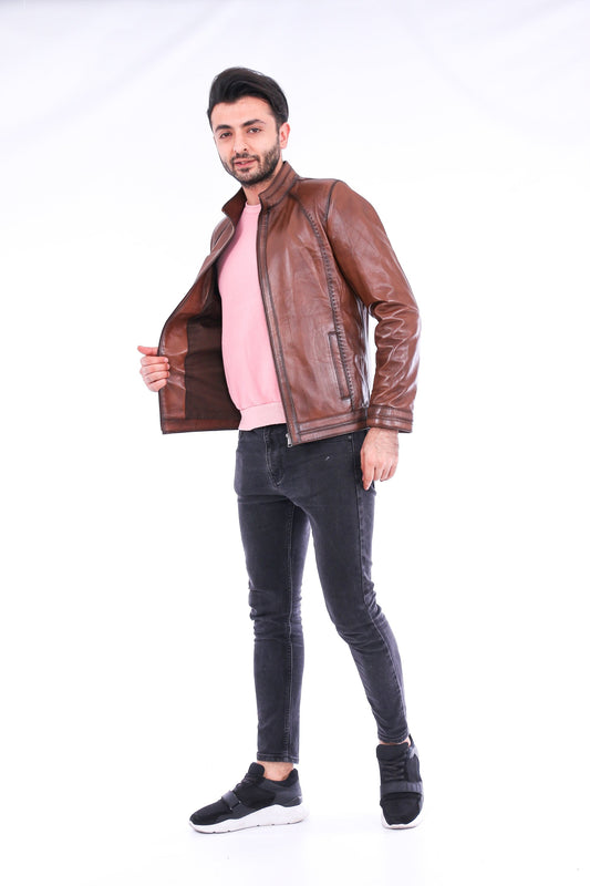 Man wearing a brown leather jacket, pink shirt, and black jeans on a white background