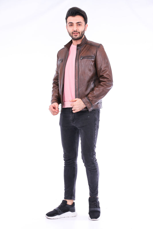 Man wearing a brown leather jacket, pink shirt, and black pants on a white background