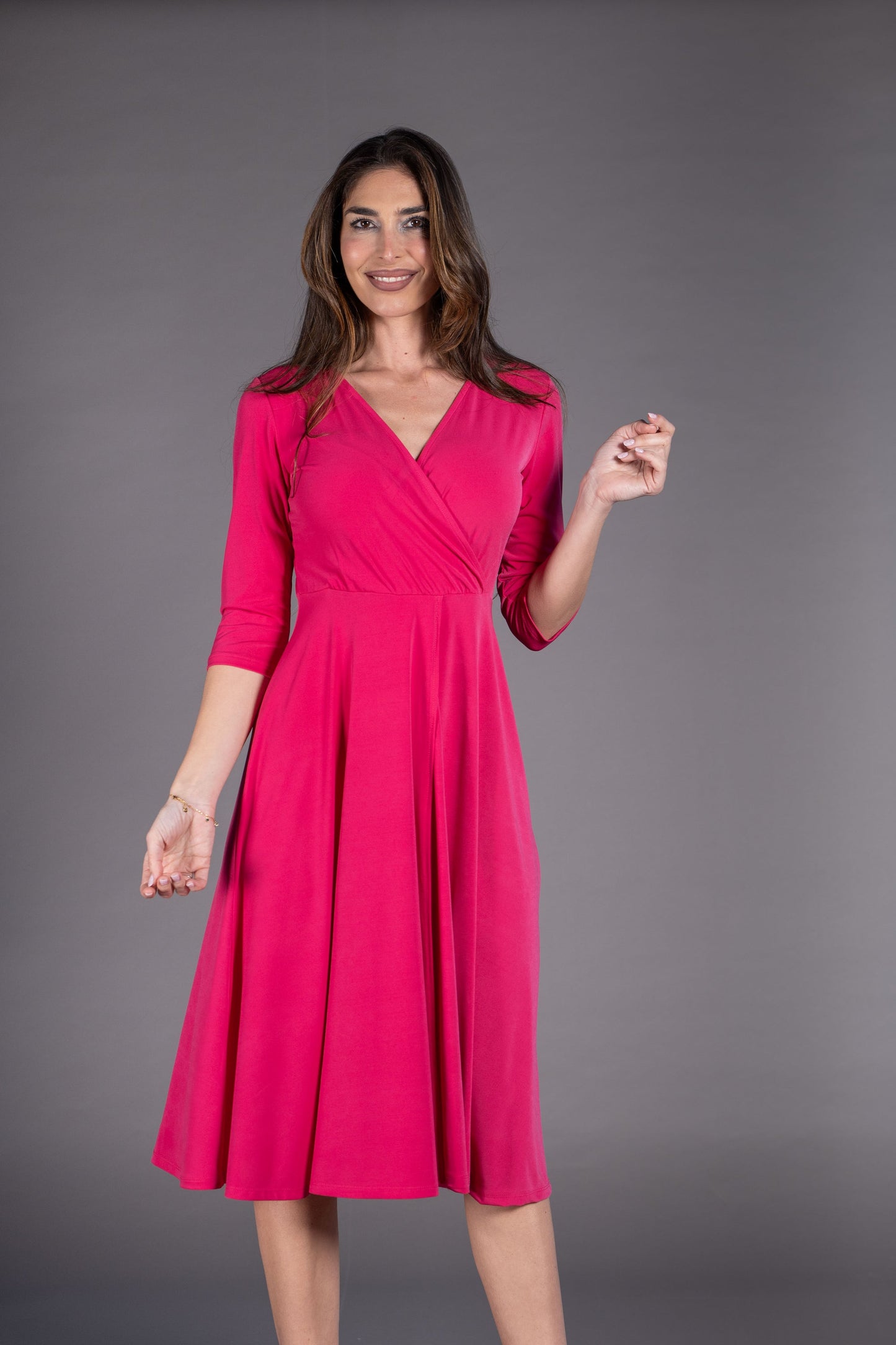 Woman wearing a pink dress against a gray background