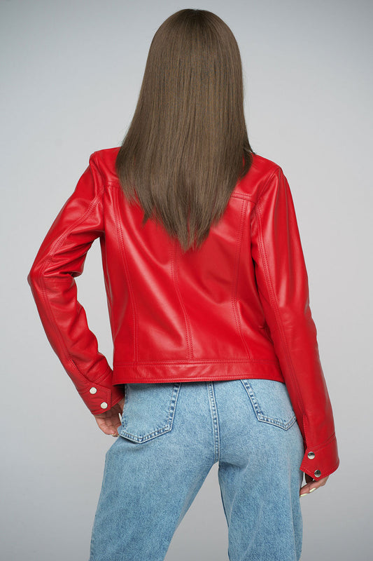 Person wearing a red leather jacket and blue jeans on a gray background