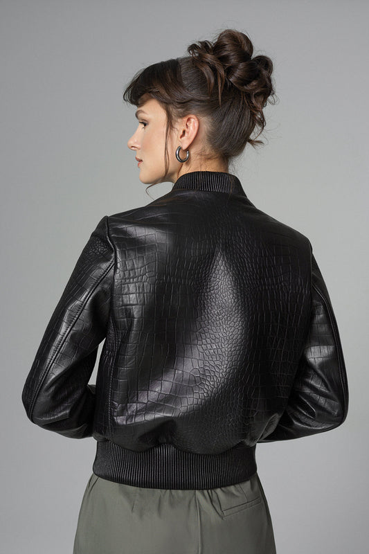 Woman wearing a black leather jacket on a gray background