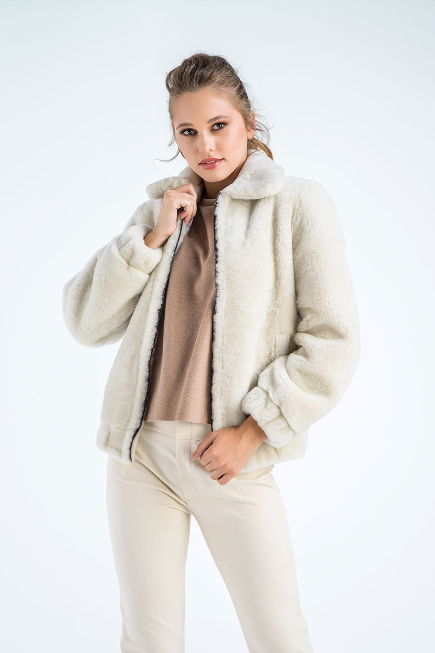 Woman wearing a cream sherpa jacket on a white background