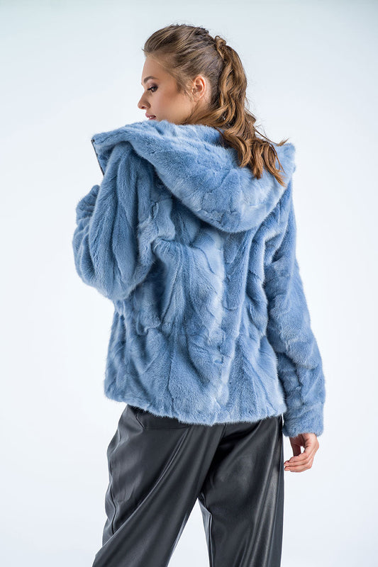 Woman wearing a blue fluffy jacket on a white background