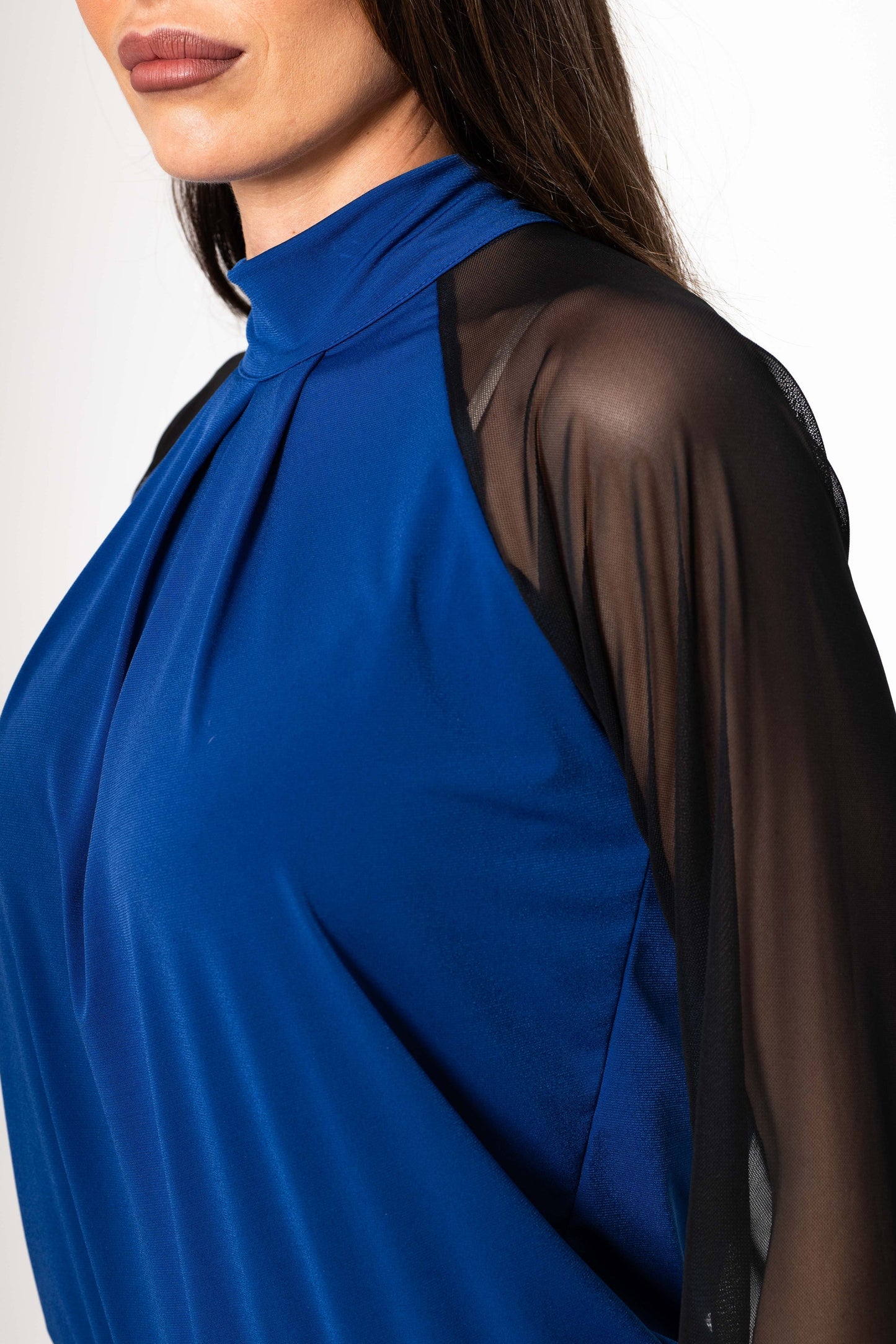Blue top with sheer black sleeves on a white background