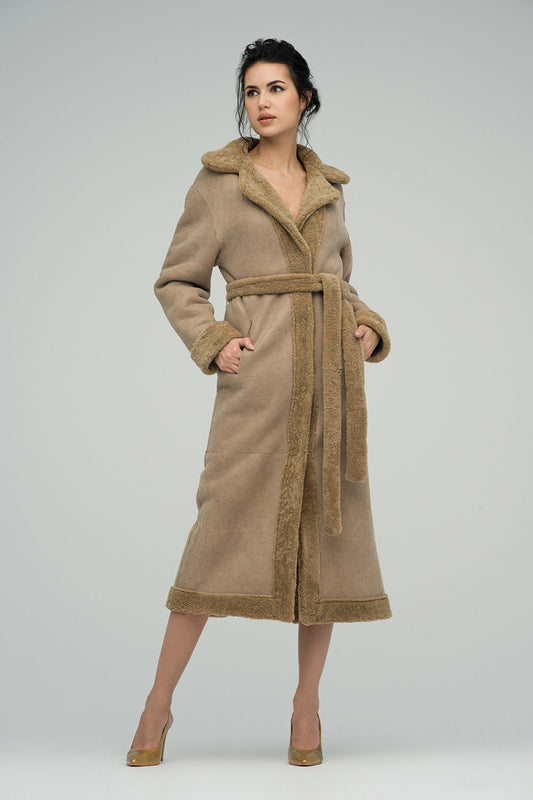 Woman wearing a long beige coat with fur trim on a white background