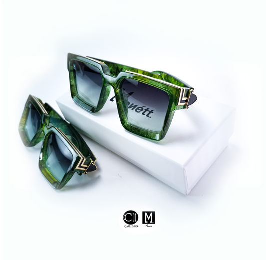 Green sunglasses with gold accents on a white surface, featuring the brand 'CIM'.