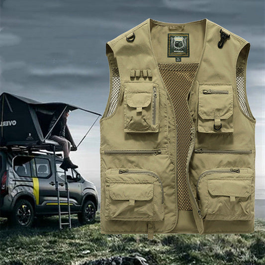 Beige tactical vest with multiple pockets on a grassy background with a vehicle and rooftop tent.
