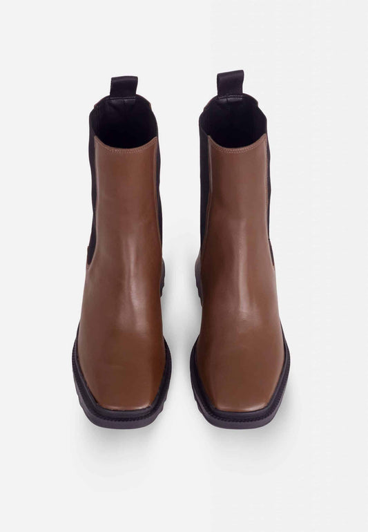 Pair of brown leather ankle boots on a white background