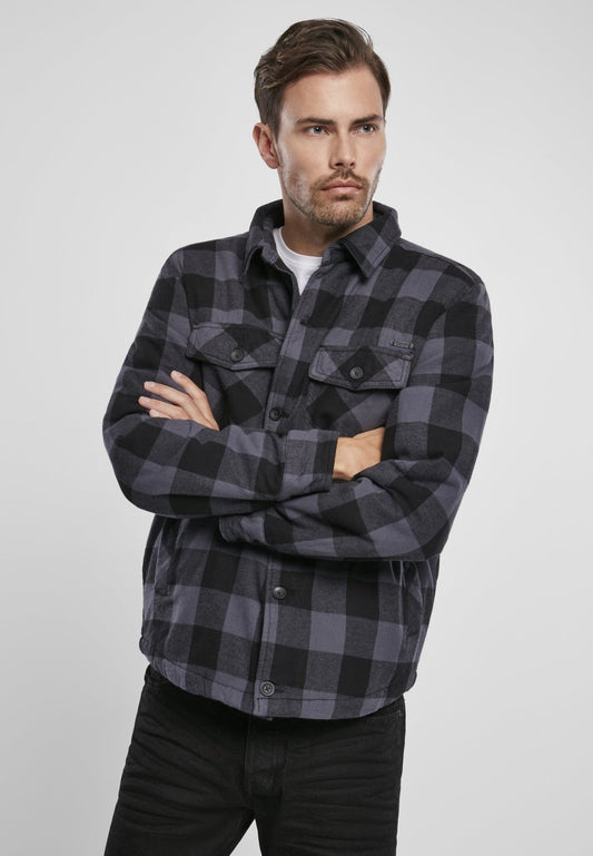 Man wearing a black and gray checkered shirt with a brand logo on a white background
