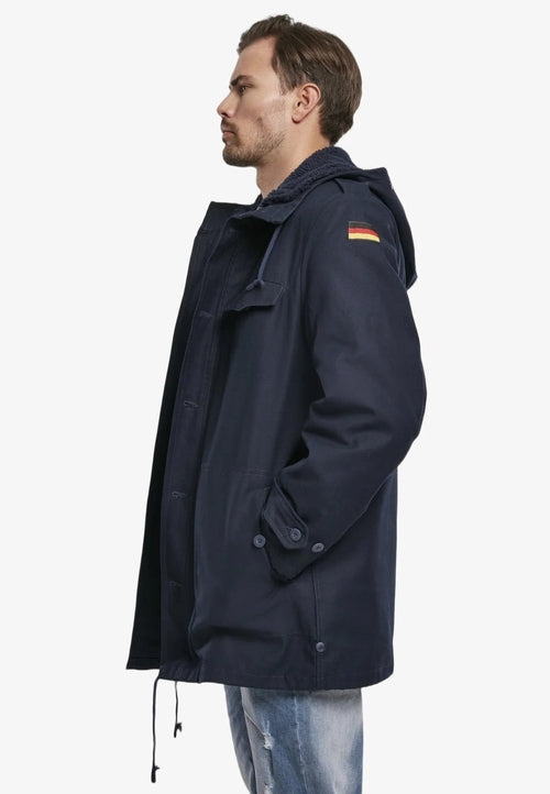 Man wearing a navy blue raincoat with a hood on a white background