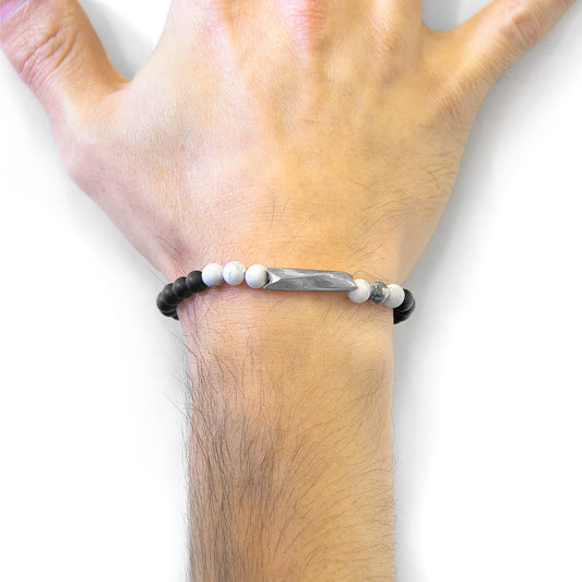 Hand wearing a beaded bracelet on a white background