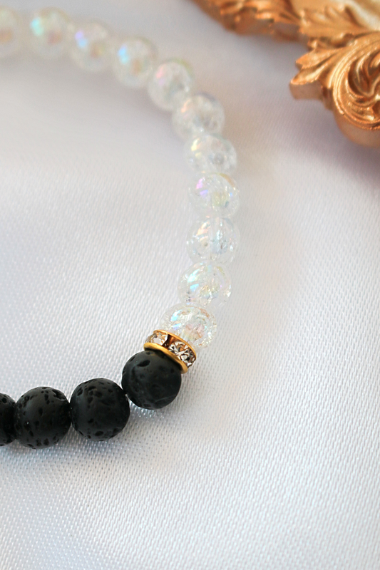 Bracelet with black beads and a gold accent on a white background