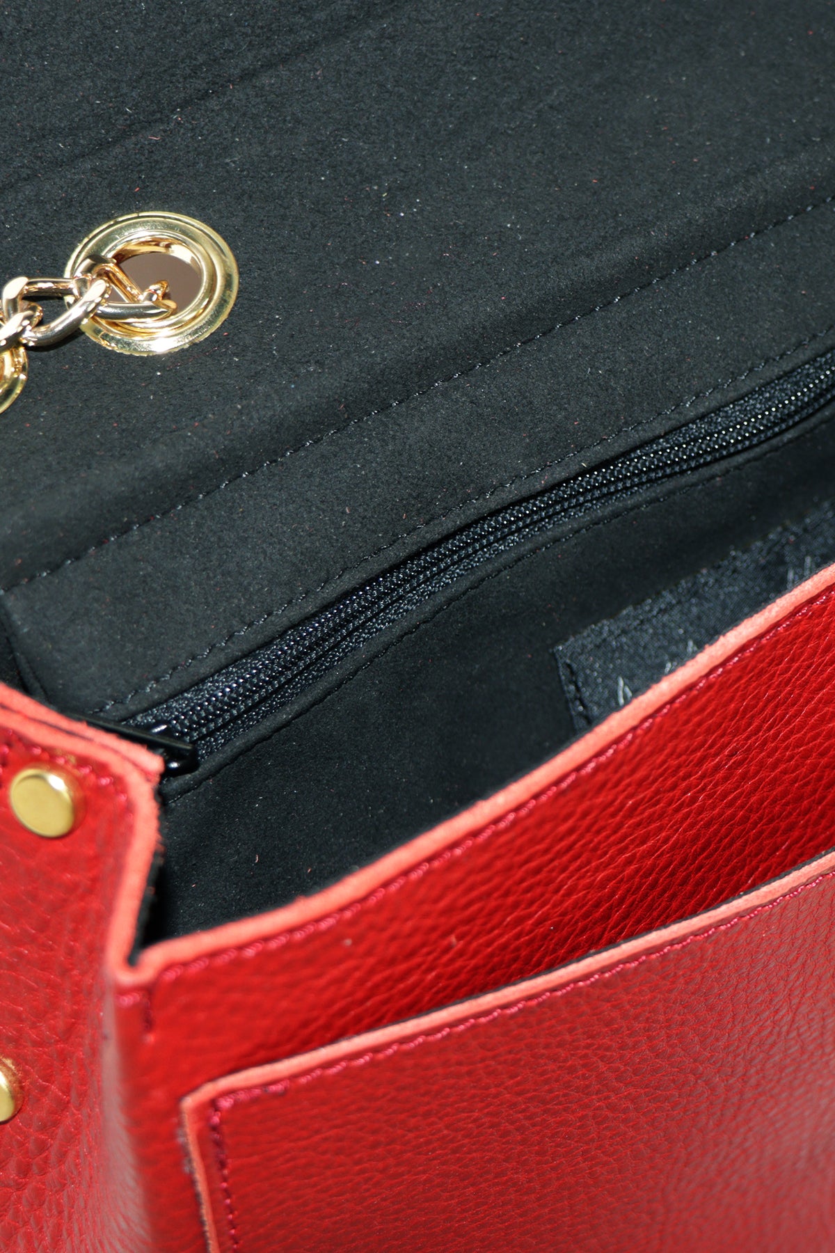 Close-up of a red leather wallet with gold accents and a black interior.