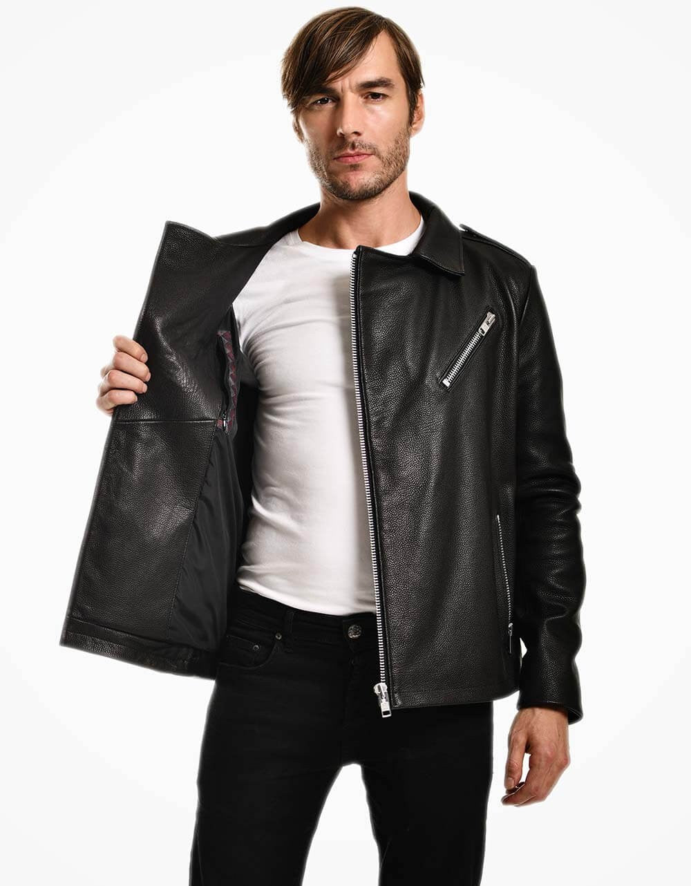 Man wearing a black leather jacket over a white shirt on a white background
