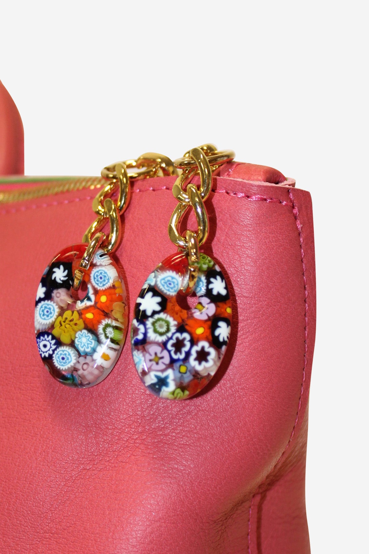 Colorful Murano glass earrings on a pink handbag