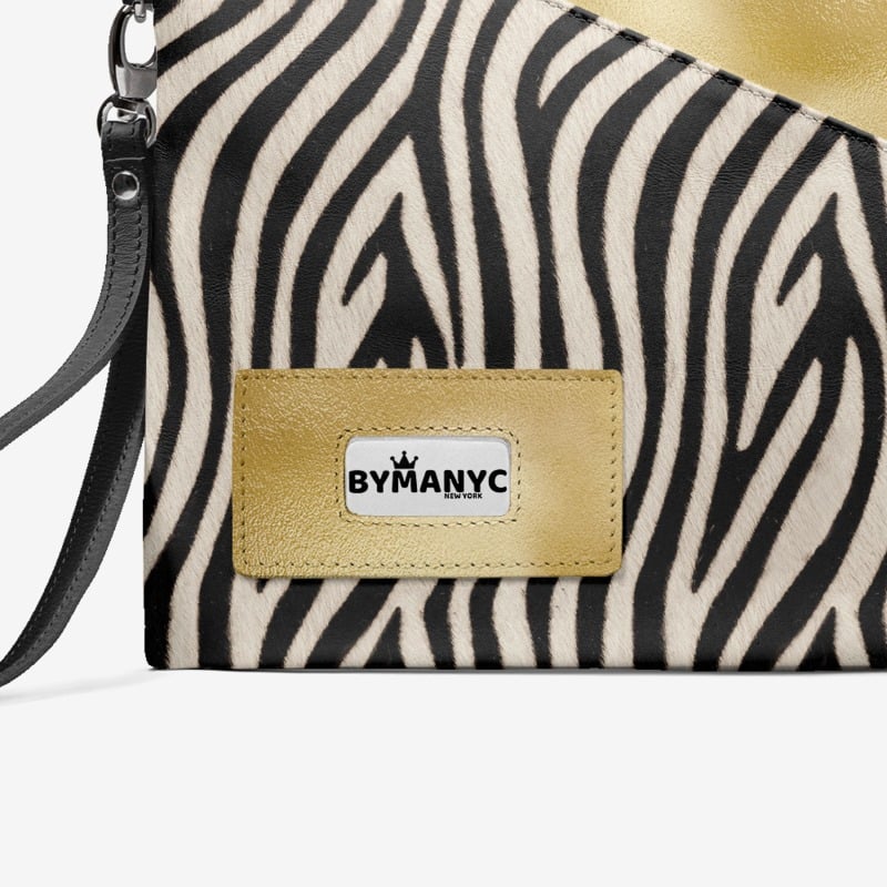 Zebra patterned handbag with a gold patch displaying 'BY MANYC' on a white background