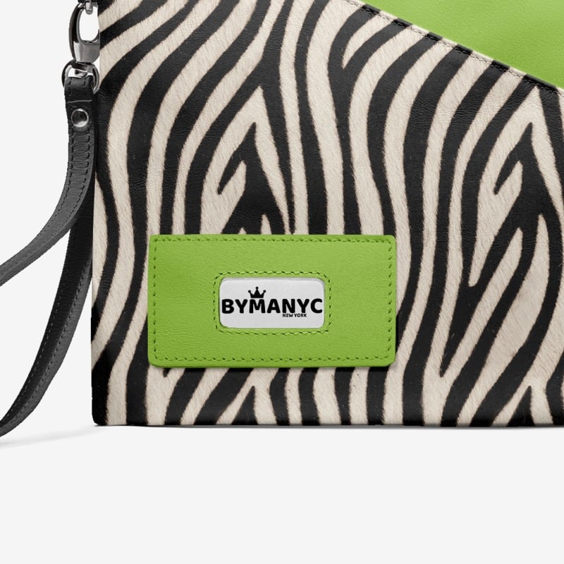 Zebra patterned clutch with a green By Many C logo on a white background