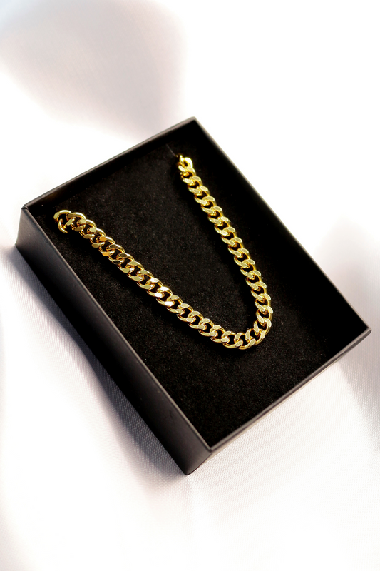 Gold chain necklace in a black box on a white background