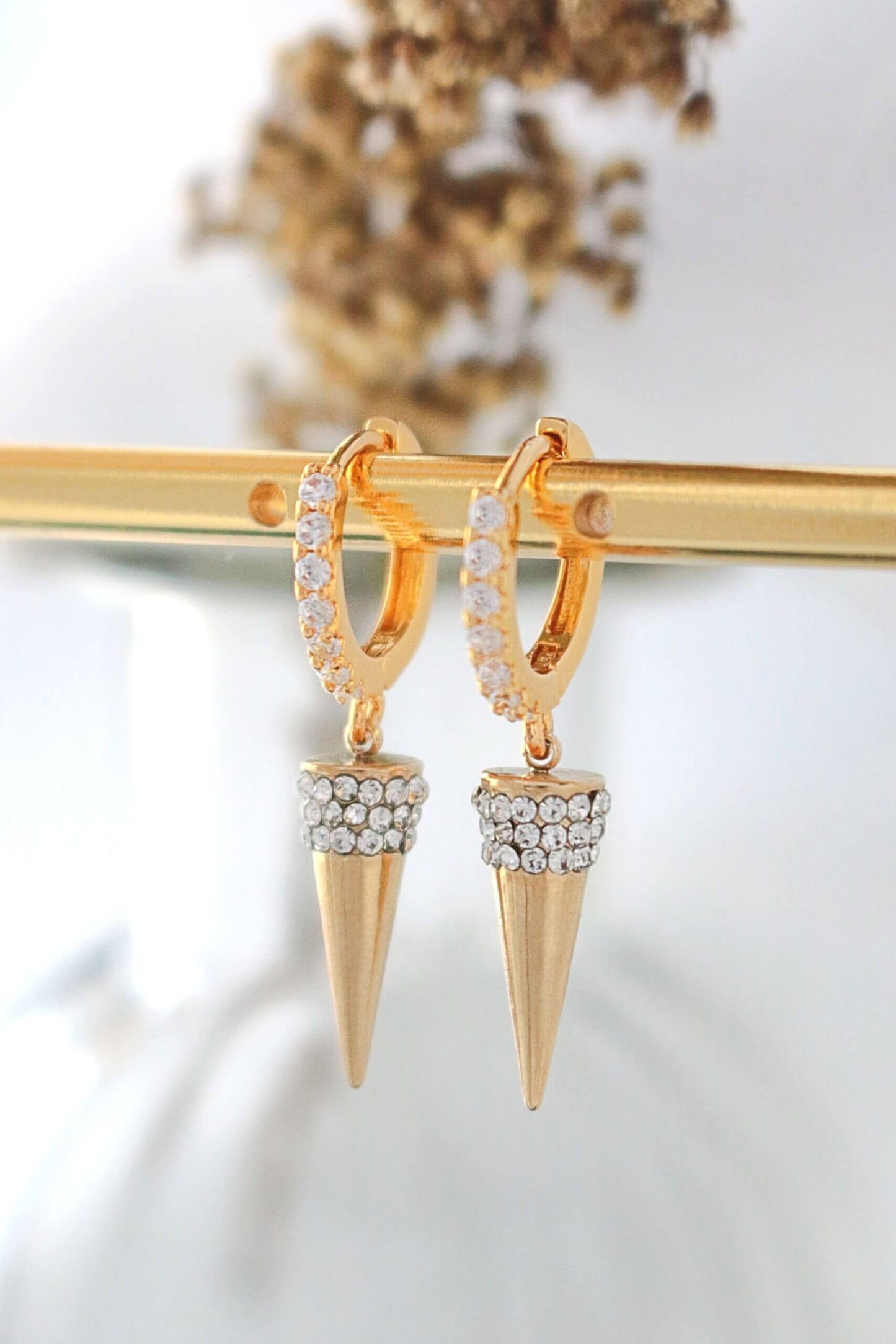 Gold hoop earrings with spike designs on a white background