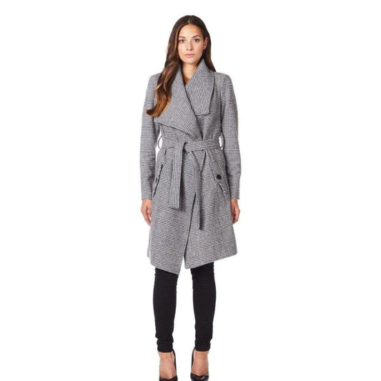 Woman wearing a gray houndstooth patterned coat on a white background