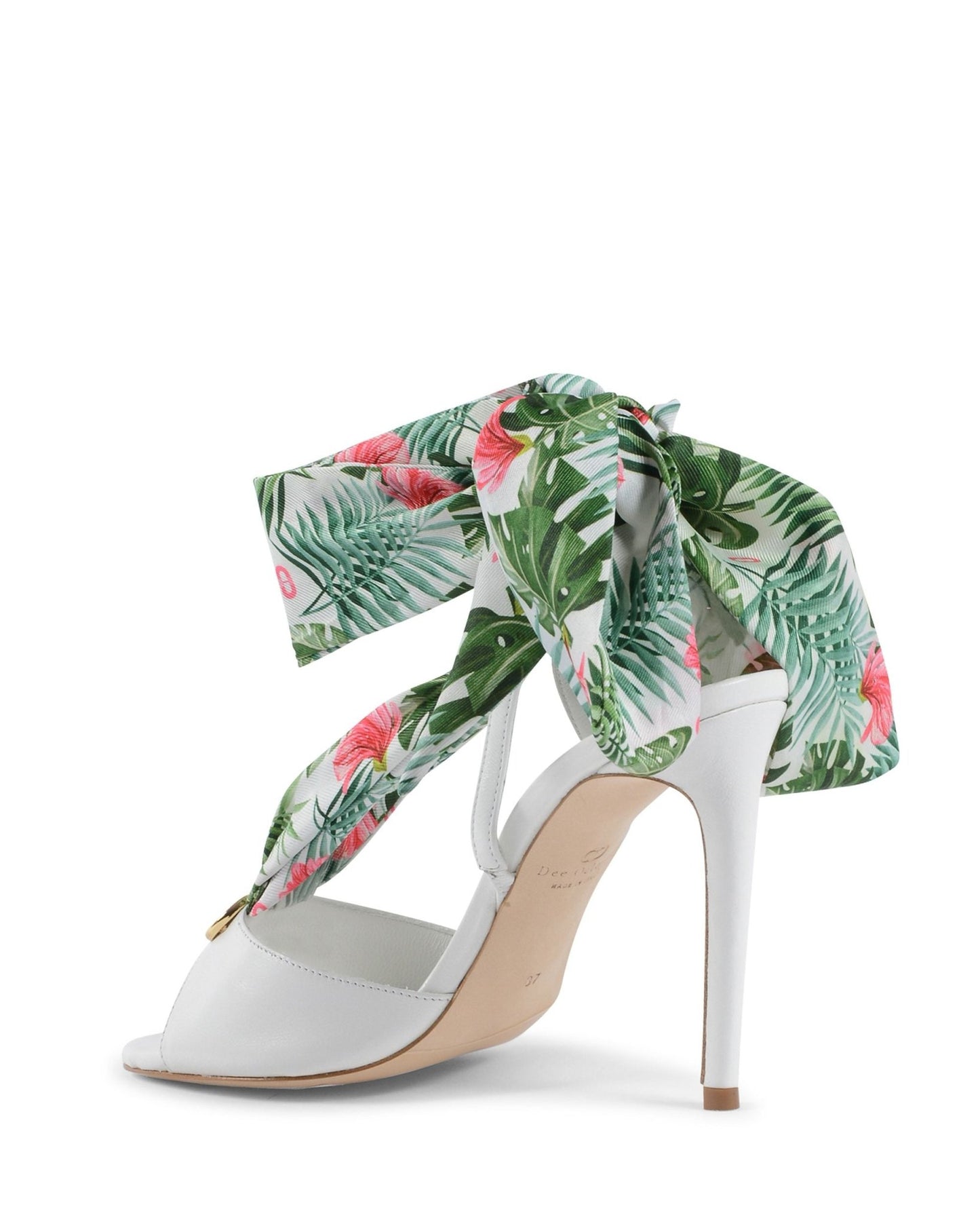 White high-heeled shoe with a tropical leaf patterned ribbon on a white background