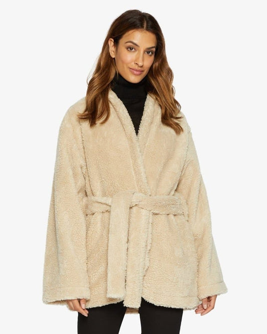 Woman wearing a beige robe with a white background