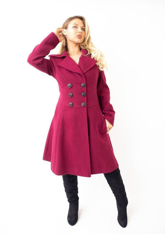 Woman wearing a pink coat with black buttons on a white background