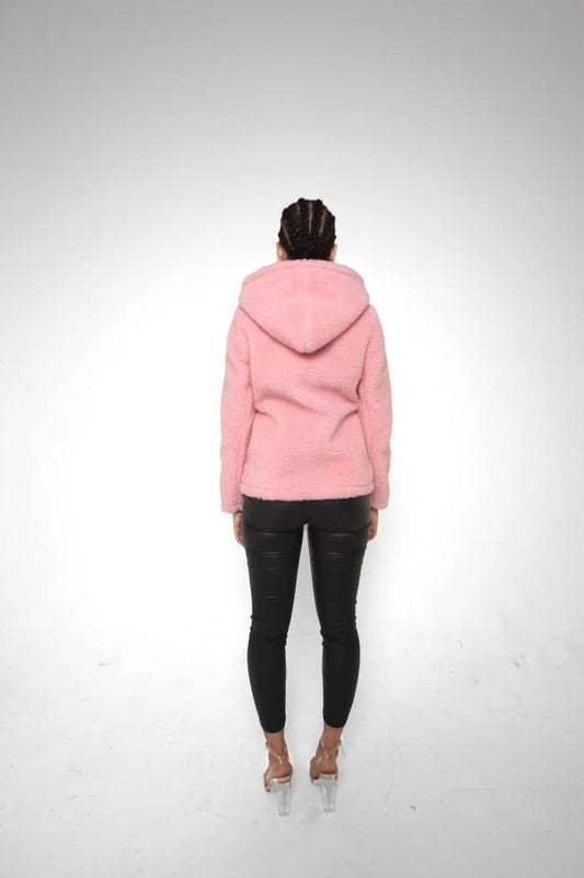 Person wearing a pink hoodie and black pants on a white background