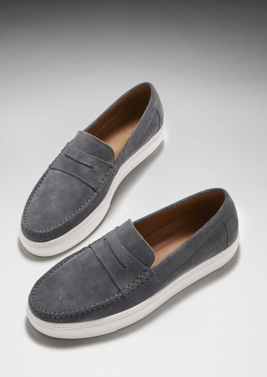Pair of gray loafers with white soles on a light gray background