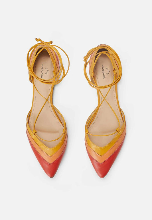 Pair of yellow and red pointed-toe shoes with strappy design on a white background