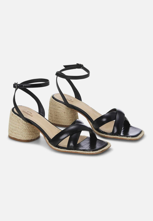Black sandals with woven soles on a white background