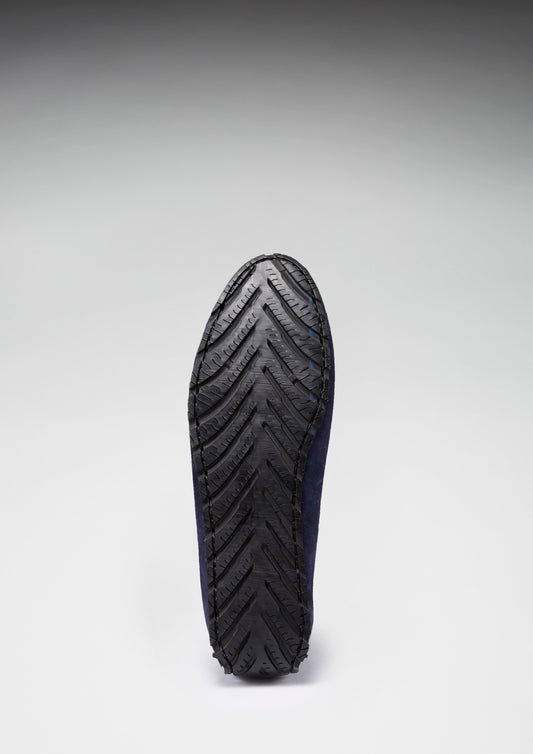 Black shoe sole with a zigzag pattern on a gray background