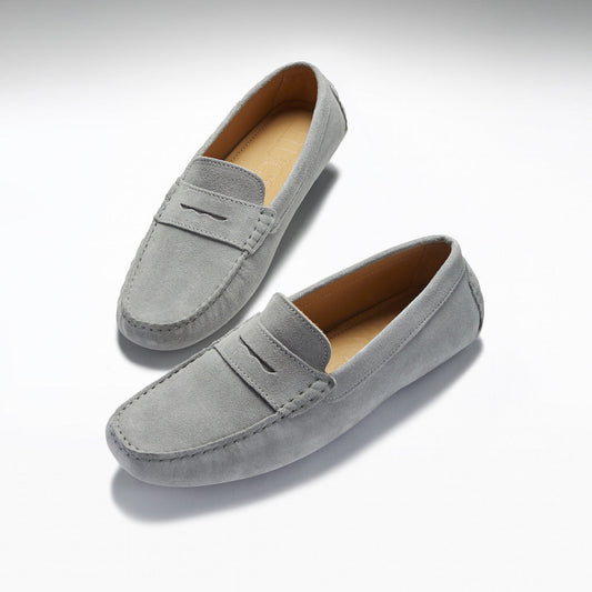 Pair of gray suede loafers on a light gray background