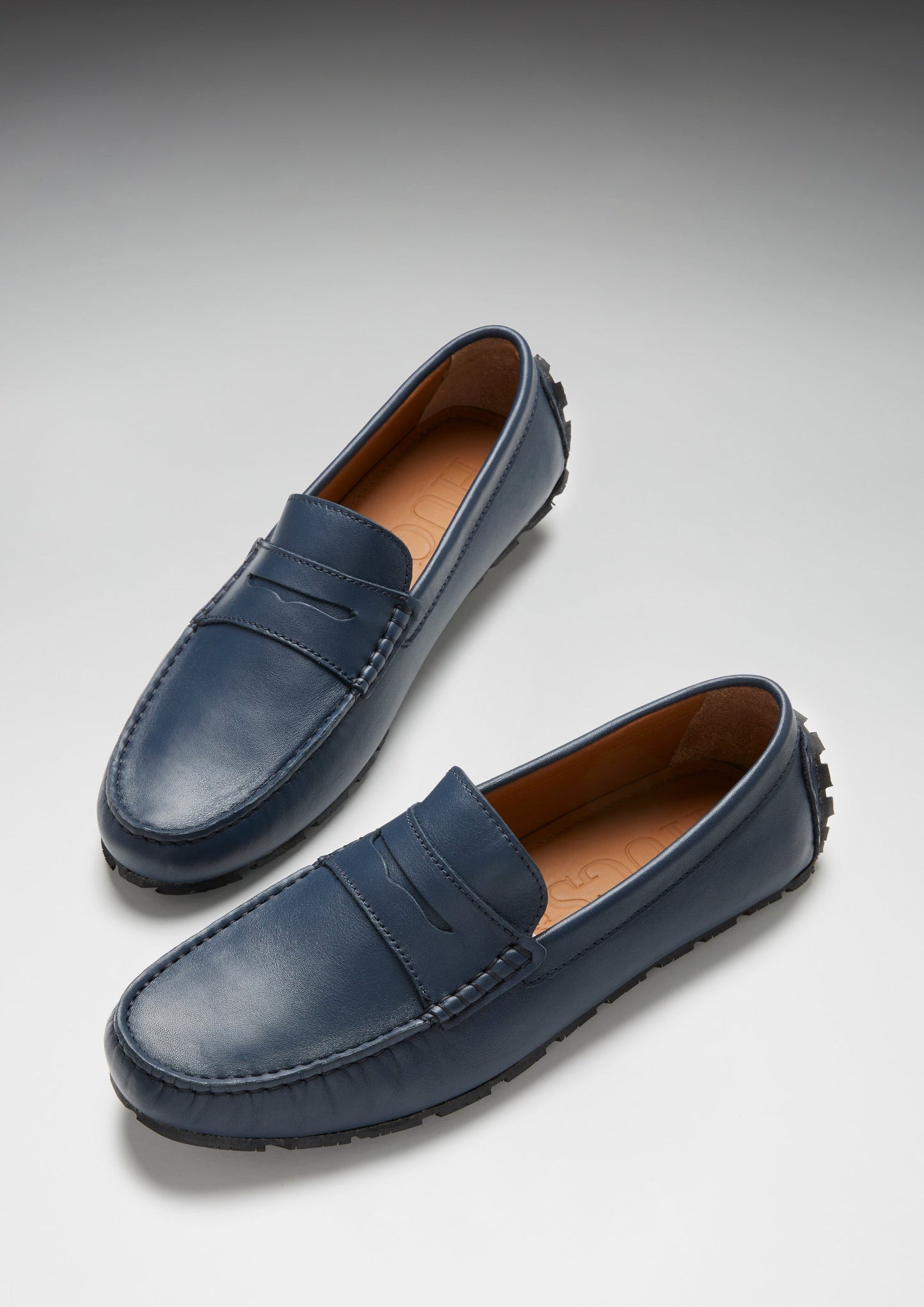 Pair of blue loafers on a light gray background