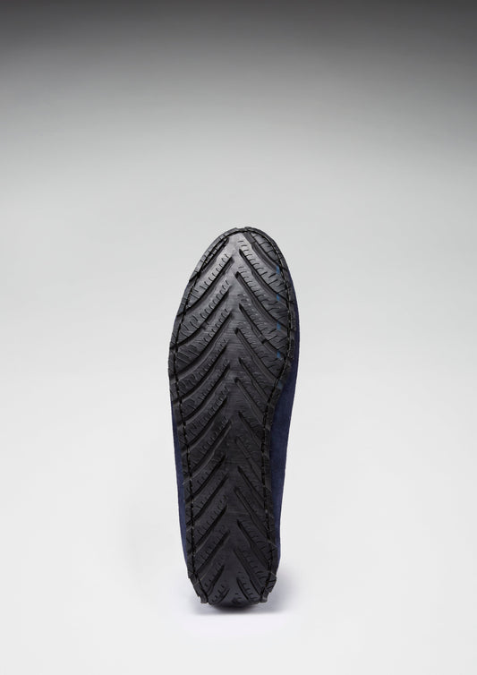 Black shoe sole with a zigzag pattern on a gray background