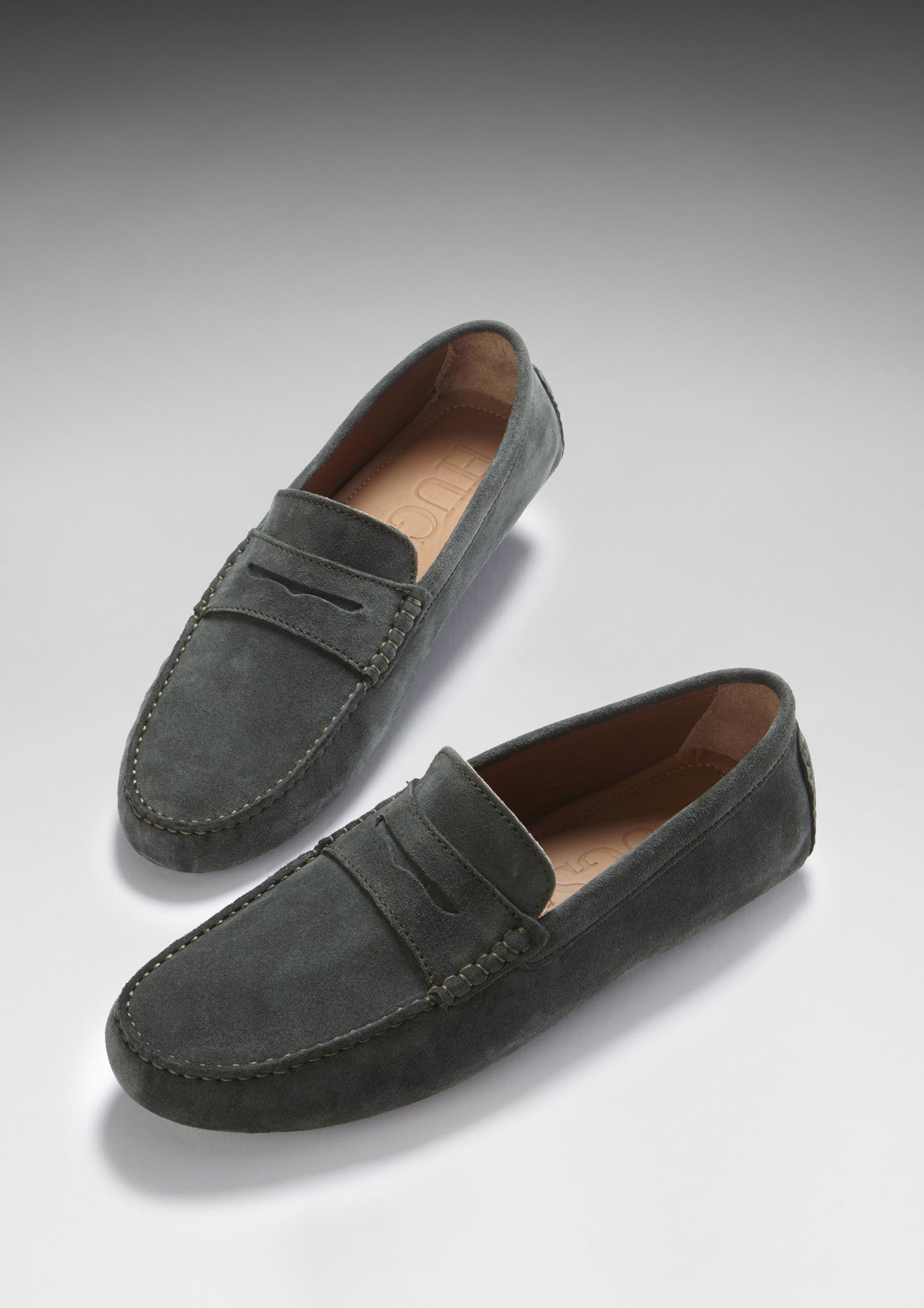 Pair of gray suede loafers on a light gray background