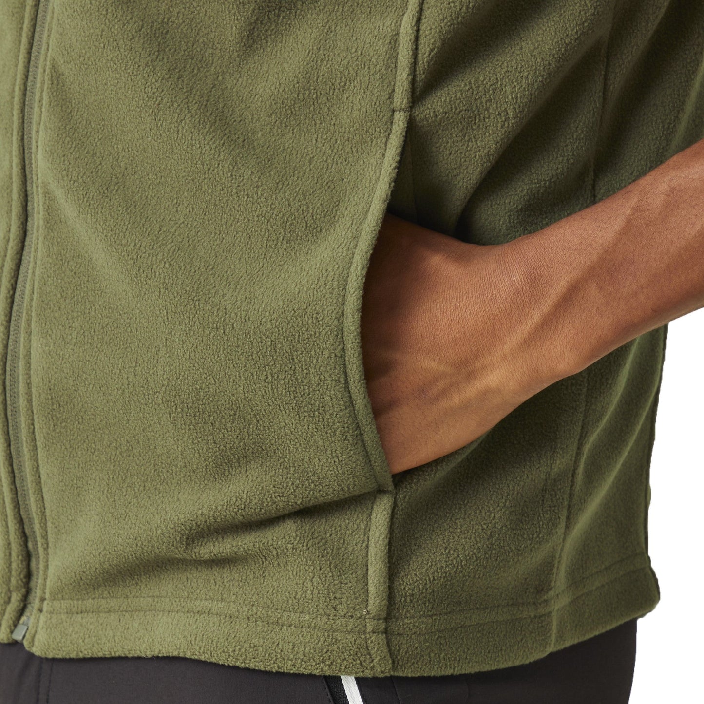 Close-up of a person wearing a green fleece jacket with a neutral background