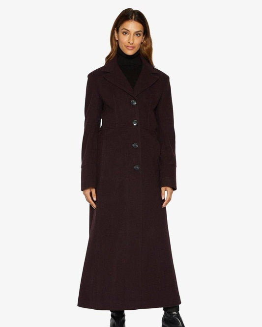 Woman wearing a long dark coat on a white background