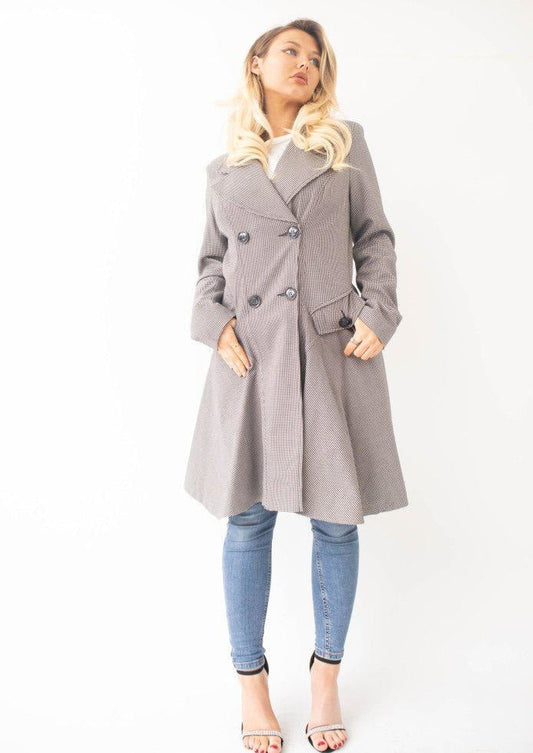 Woman wearing a gray coat and blue jeans on a white background