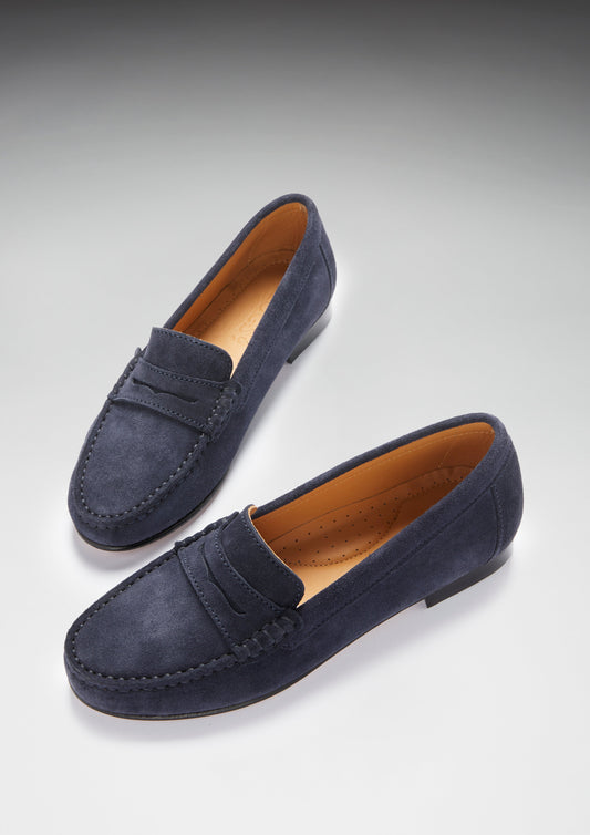 Pair of navy blue loafers on a light gray background