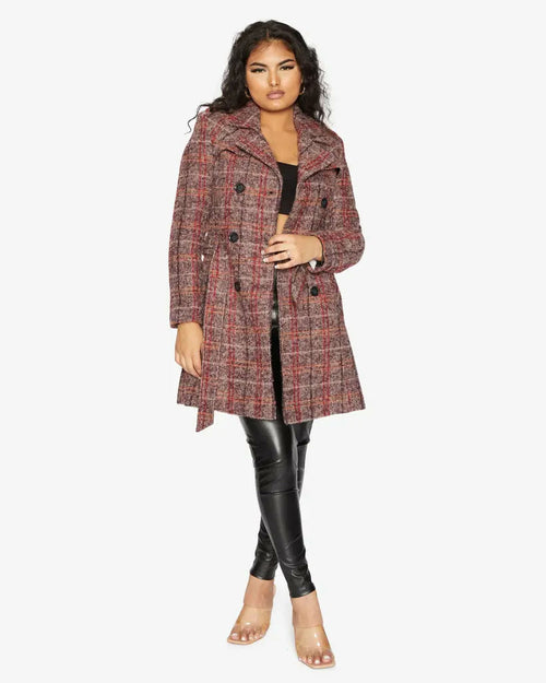 Woman wearing a plaid coat and black leggings on a white background