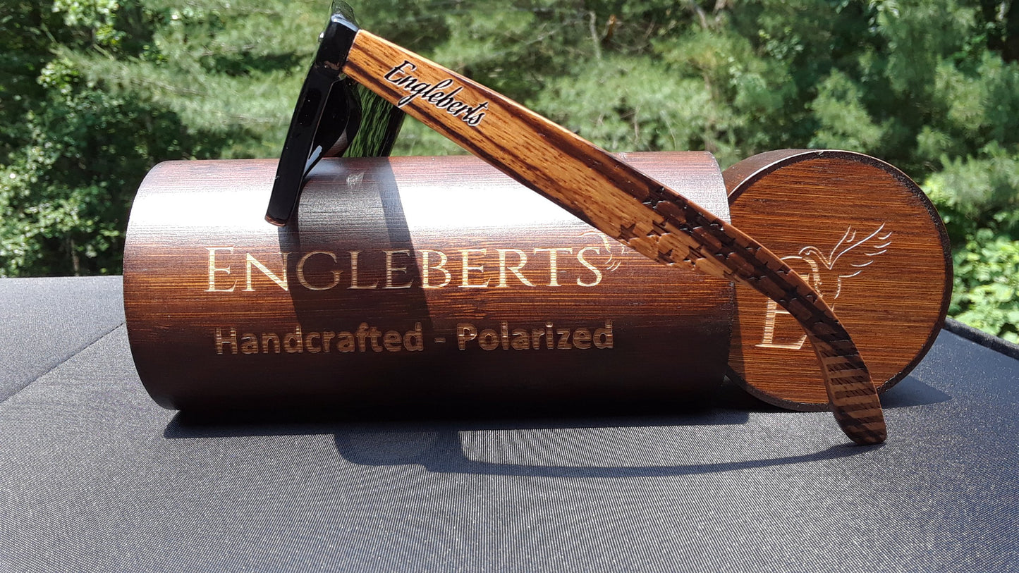 Wooden sunglasses case with a wooden frame on a reflective surface, outdoors.