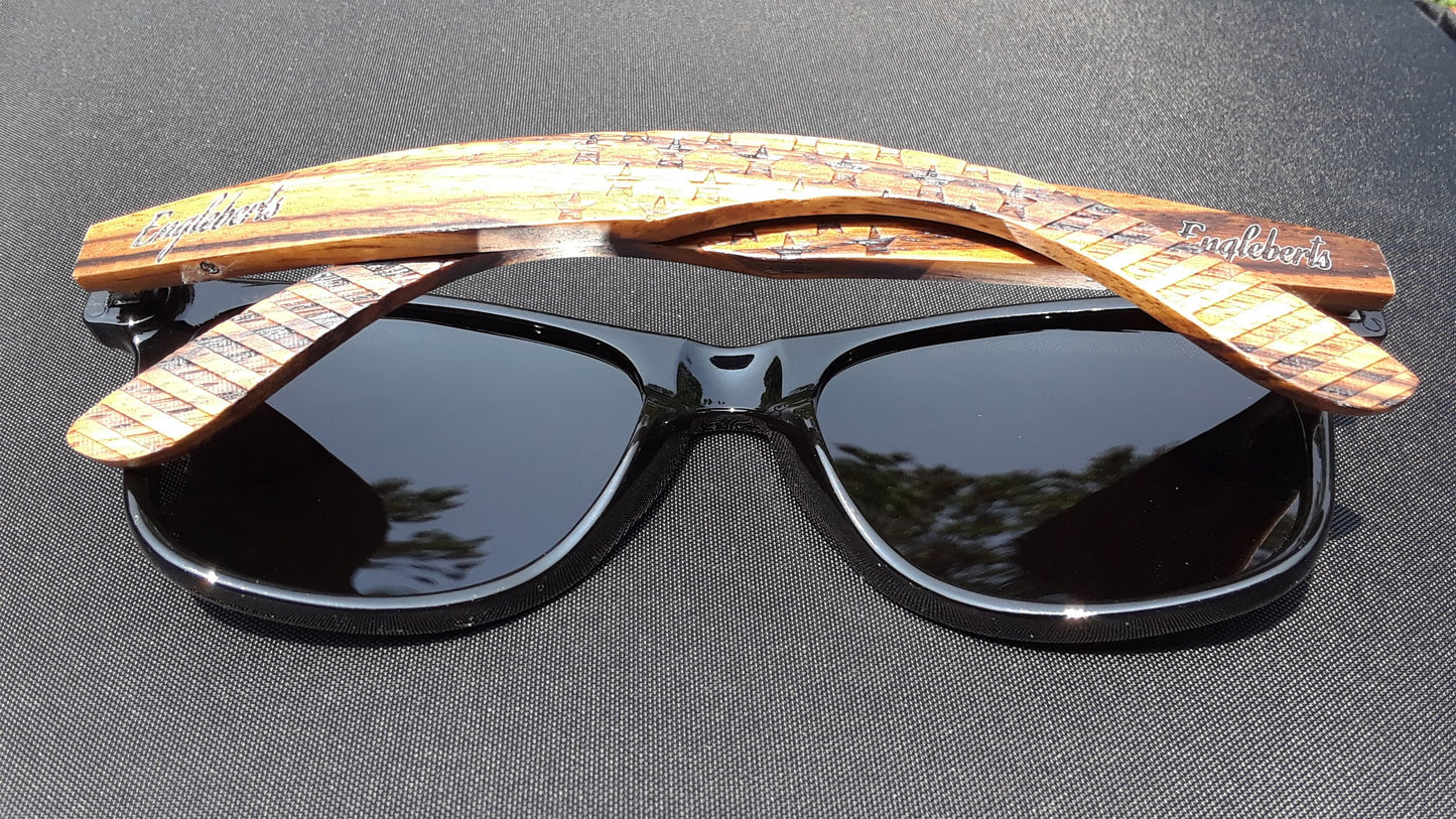Black sunglasses with wooden arms on a dark surface