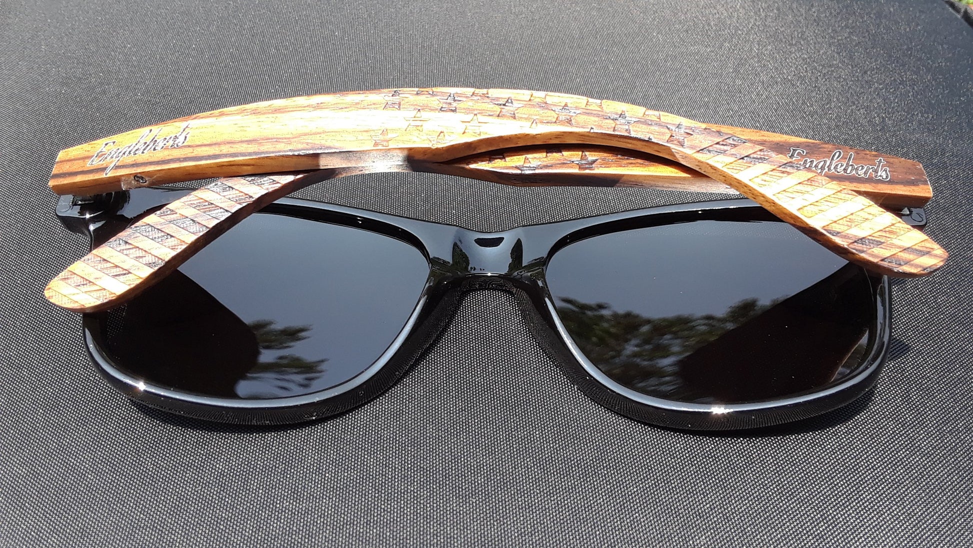 Black sunglasses with wooden arms on a dark surface