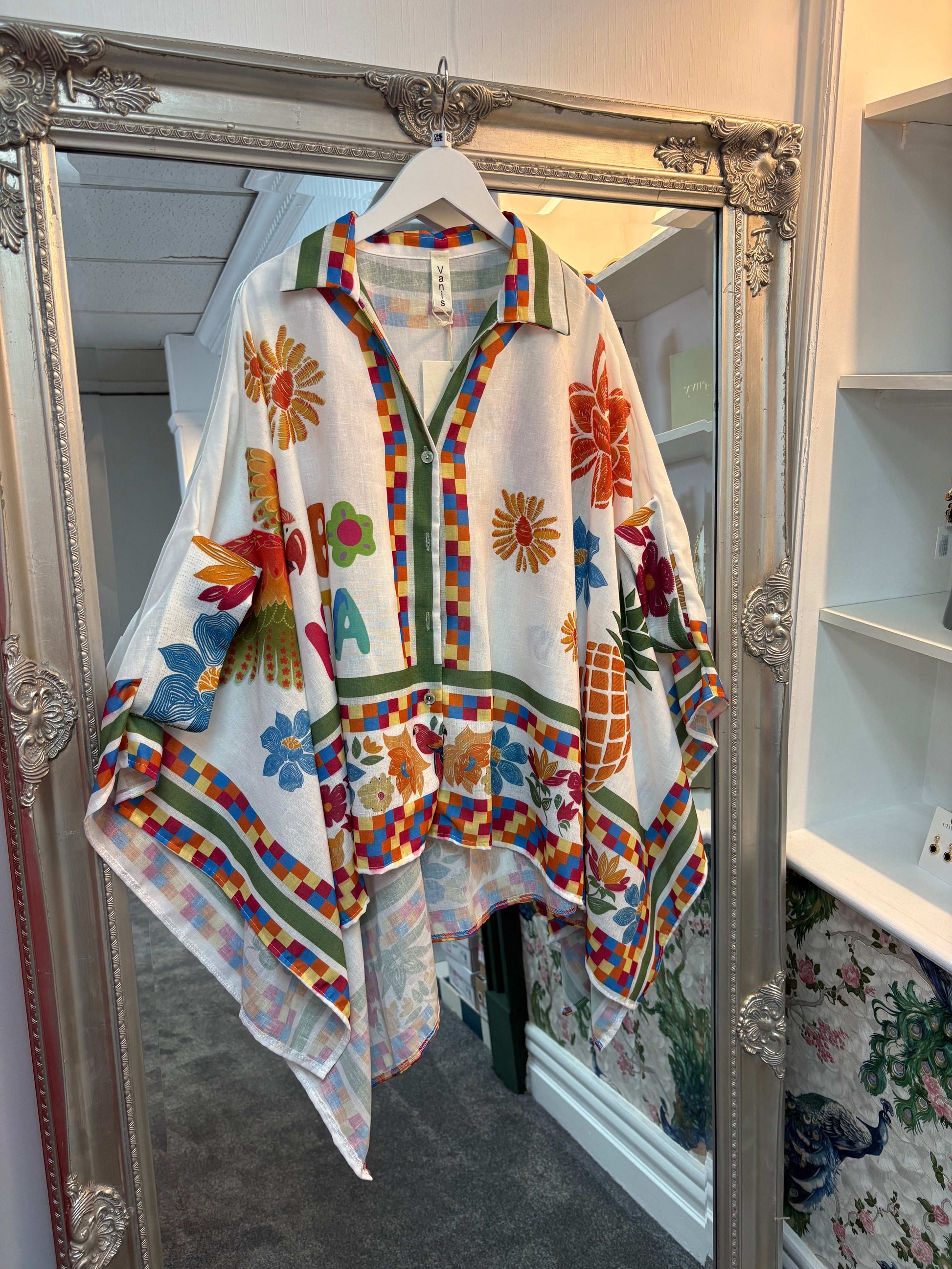 Colorful floral-patterned jacket hanging in front of a mirror.